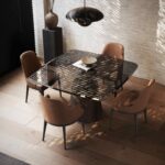 Een moderne eetkamer heeft een vierkante glazen tafel met vier Anna Stoel Met Armleuning - Houten Poten stoelen op een lichte houten vloer. Een zwarte hanglamp hangt erboven, natuurlijk licht filtert door jaloezieën die schaduwen werpen en een decoratieve vaas siert de tafel.