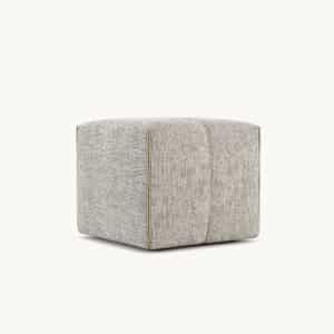 Een lichtgrijze, vierkante Grant S Poef poef met structuurstof en subtiele stiksels aan de zijkanten op een witte achtergrond.