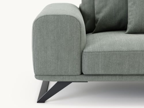 Close-up van de groene Aniston 2-zitsbank, die het moderne, minimalistische design laat zien met een brede, gewatteerde armleuning en strakke metalen poten. De subtiel getextureerde bekleding is benadrukt tegen een lichte achtergrond.