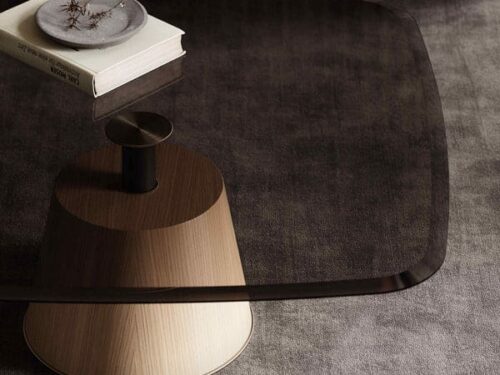 Salontafel Brelirrocca van eikenhout met laag, afgerond blad en donkere metalen details in een modern interieur