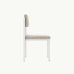 Minimalistische moderne stoel met witte houten frame en beige bekleding, zijaanzicht. Geschikt voor eigentijds interieur.