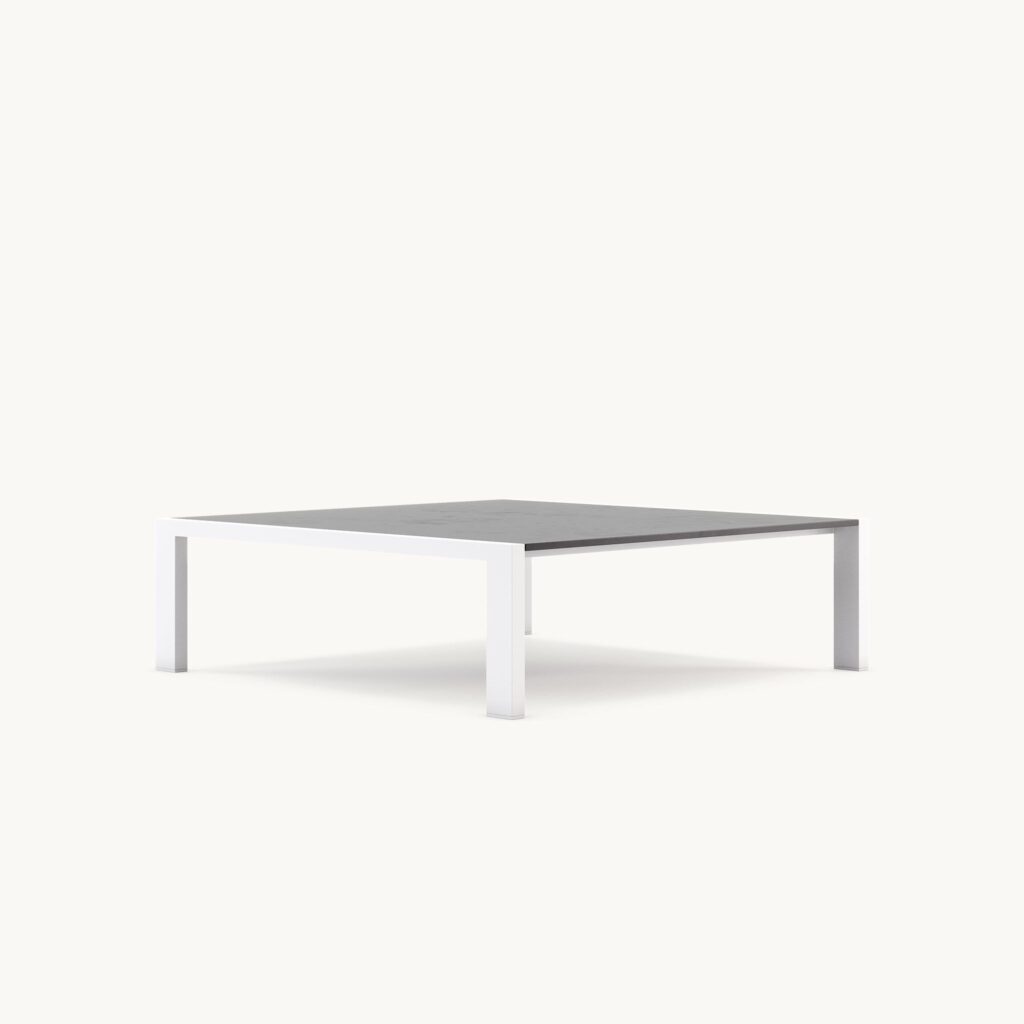 Minimalistisch vierkante salontafel met wit metalen frame en donker blad, ideaal voor moderne interieurs.
