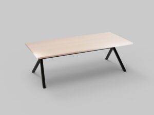 Een minimalistische houten tafel met een lichtgekleurd rechthoekig blad en zwarte metalen poten die schuin zijn geplaatst, tegen een effen grijze achtergrond.