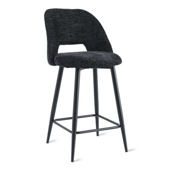 Een moderne barkruk met een zwarte stoffen zitting en rugleuning, met een uitsparing. De kruk heeft vier schuine metalen poten met een strakke zwarte afwerking en een voetensteun die de voorpoten verbindt.