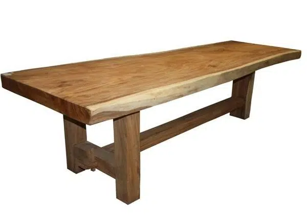 Een houten tafel met een rustieke, natuurlijke afwerking. Het tafelblad heeft een ongelijke, organische rand en wordt ondersteund door stevige rechthoekige poten die met elkaar verbonden zijn door een horizontale balk.