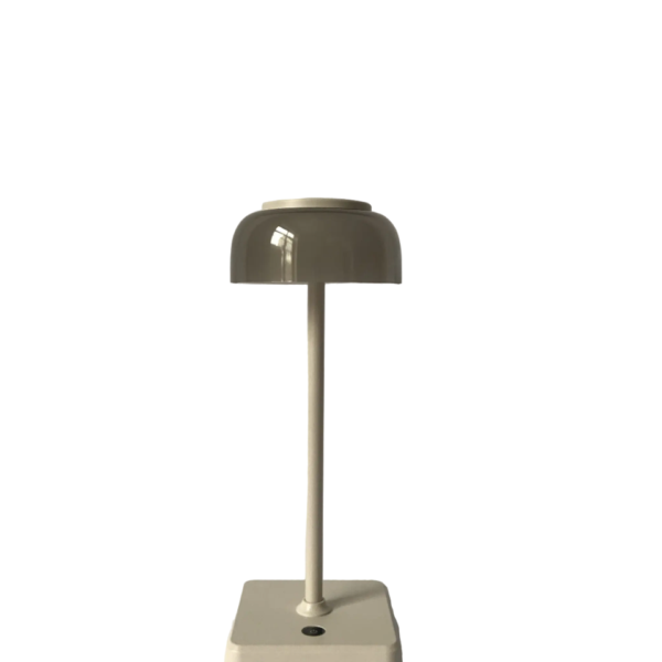 Een moderne beige tafellamp met een koepelvormige kap staat op een vierkante basis met een knop. Het ontwerp van de lamp is strak en minimalistisch, tegen een effen witte achtergrond.