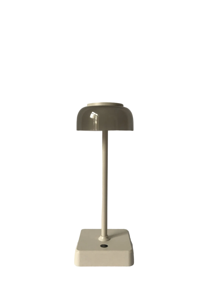 Een moderne beige tafellamp met een koepelvormige kap staat op een vierkante basis met een knop. Het ontwerp van de lamp is strak en minimalistisch, tegen een effen witte achtergrond.