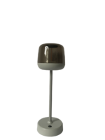Een moderne tafellamp met een strak design, met een grijze basis en paal die een metalen, koepelvormige kap ondersteunt. De lamp is uitgeschakeld en geïsoleerd op een witte achtergrond.