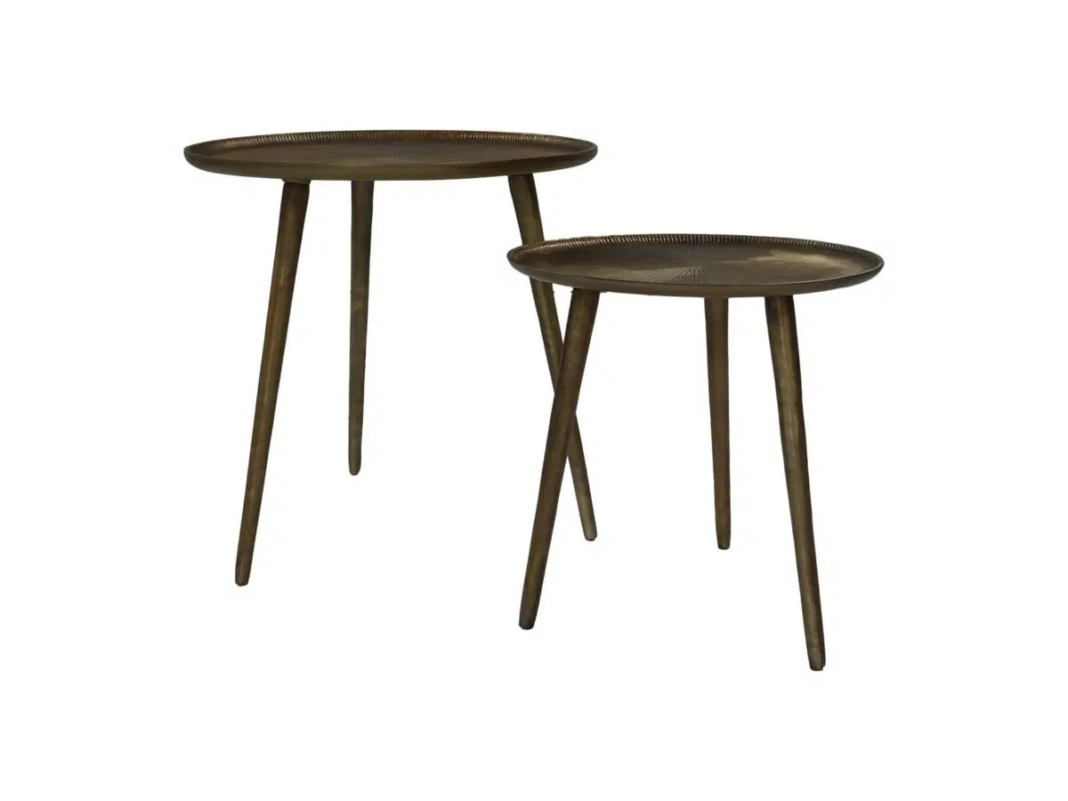 Twee ronde, bronzen nesttafels met elk drie slanke poten. De ene tafel is iets hoger dan de andere, waardoor een gelaagd effect ontstaat. Beide hebben een rustieke, metalen afwerking met een eenvoudig, minimalistisch ontwerp.