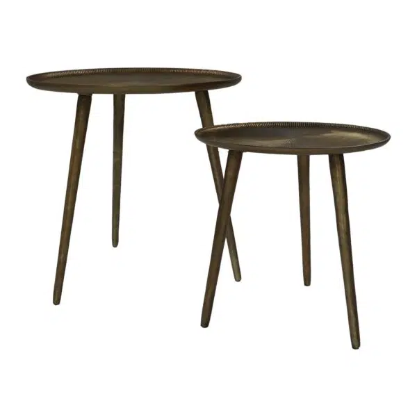 Twee ronde, bronzen nesttafels met elk drie slanke poten. De ene tafel is iets hoger dan de andere, waardoor een gelaagd effect ontstaat. Beide hebben een rustieke, metalen afwerking met een eenvoudig, minimalistisch ontwerp.