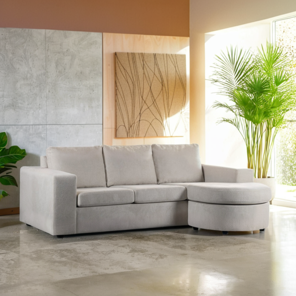 Moderne woonkamer met de 3-zitsbank CL L+R in stof Lord 22, E460 beige, aangevuld met abstracte wandkunst, grote groene potplanten en natuurlijk licht dat door een raam naar binnen stroomt.