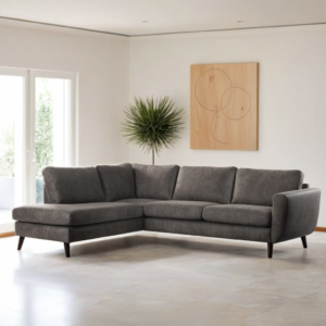 Moderne woonkamer met 3-zits hoek links, Stof Yuma 34, S520 taupe L-vormige bank, lichte tegelvloer, witte muren, een potplant, groot raam met transparante gordijnen en abstracte houten wandkunst.