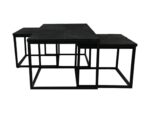 Drie moderne, zwarte nesttafels met geometrische, open metalen onderstellen en vierkante bladen zijn bij elkaar geplaatst. De tafels hebben een strak en minimalistisch design, met de grootste in het midden en twee kleinere gedeeltelijk daaronder.