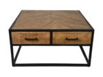 Vierkante houten salontafel met een visgraatmotief aan de bovenkant, met twee lades aan de voorkant met zwarte handgrepen. De tafel heeft een zwart metalen frame en een minimalistisch design.