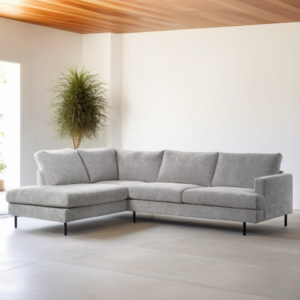 Moderne woonkamer met de 3 zits hoek links, stof Haga 08, E920 naturel L-vormige bank op zwarte poten staat op een lichte vloer. In de hoek staat een hoge groene potplant, het plafond is bekleed met houten lambrisering en er komt natuurlijk licht binnen van links.