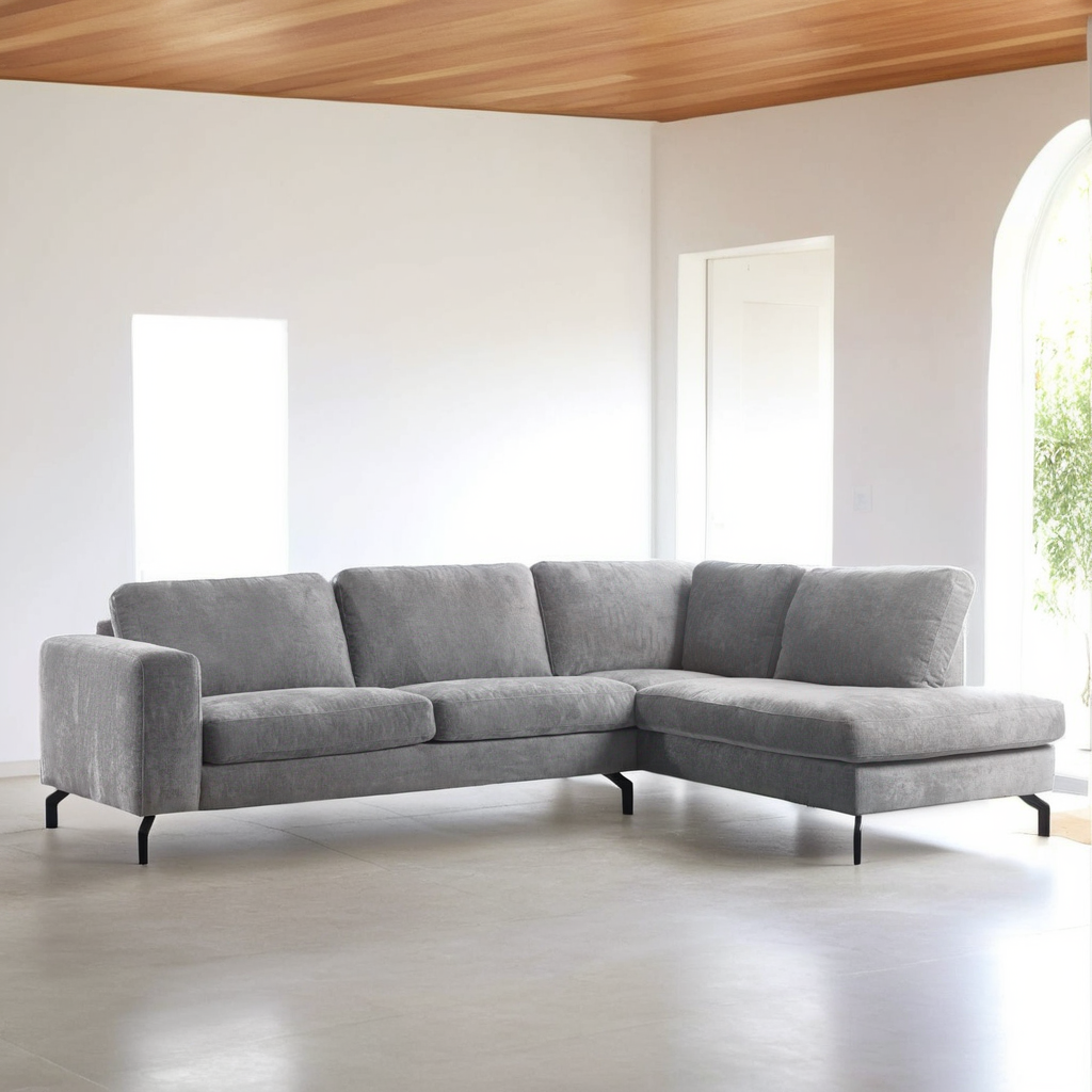 De moderne woonkamer is voorzien van de 3 zits hoek rechts, stof Perfect Harmony 82, R311 grijs L-vormige hoekbank met zwarte poten, tegen witte muren, een licht houten plafond en grote ramen die de ruimte vullen met natuurlijk licht.