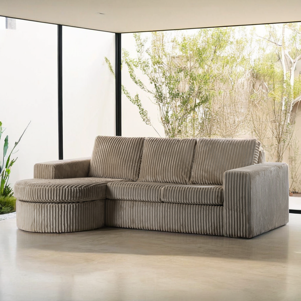 De 3 zits bank CL L+R, stof Tillia 03, L460 beige is een beige hoekbank met chaise longue, geplaatst in een moderne woonkamer met kamerhoge ramen en uitzicht op groen in natuurlijk licht.