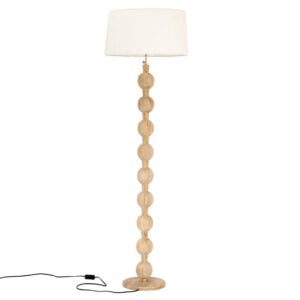 Een houten vloerlamp met een voet en steel van op elkaar gestapelde ronde houten vormen. Het heeft een witte, cilindrische lampenkap aan de bovenkant. Een zwart netsnoer met een schakelaar is zichtbaar aan de voet.