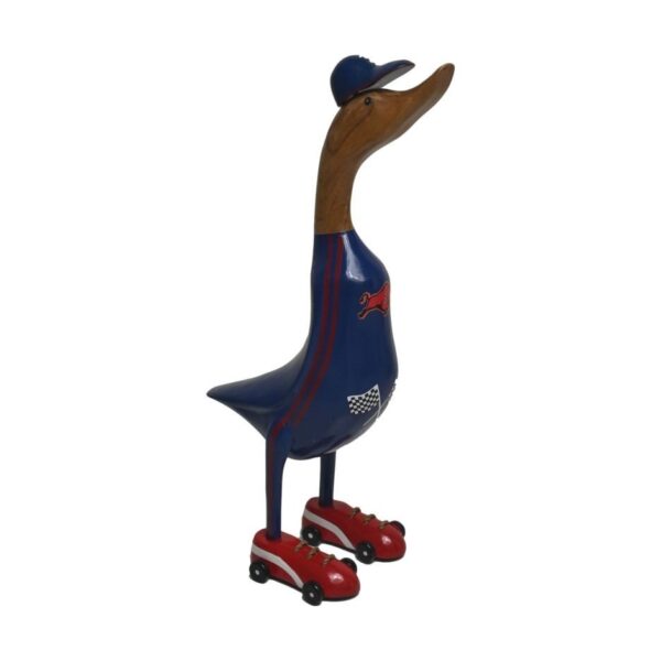 Gesneden houten eend beschilderd om op een rolschaatser te lijken, draagt een blauwe outfit met rode biezen, een bijpassende pet en rode rolschaatsen. De eend staat rechtop met een speelse uitdrukking.