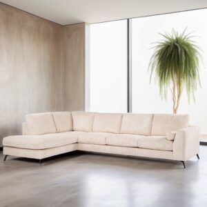 Een moderne woonkamer met een grote beige hoekbank op een gepolijste betonnen vloer. Een hoge, weelderige plant in een hoek staat bij een groot raam, waardoor natuurlijk licht de minimalistische ruimte verlicht.