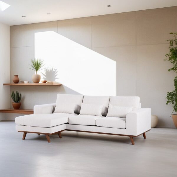 Een minimalistische woonkamer met een witte hoekbank op een lichte houten vloer. Een grote plant staat in de hoek en twee zwevende planken bevatten aardewerk en kleine planten. Zonlicht werpt een rechthoekig licht op de neutrale muur.