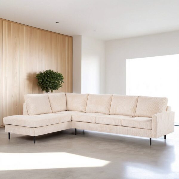 Een beige L-vormige sectionele bank met dunne zwarte poten staat in een minimalistische woonkamer. De kamer heeft een lichte houten lambrisering en een kleine groene plant. Zonlicht stroomt door een groot raam naar binnen en verlicht de grijze vloer.
