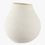 Een peervormige, getextureerde witte vaas met een brede basis en een smalle, off-center opening tegen een effen achtergrond. De vaas heeft een minimalistisch ontwerp en een glad oppervlak.