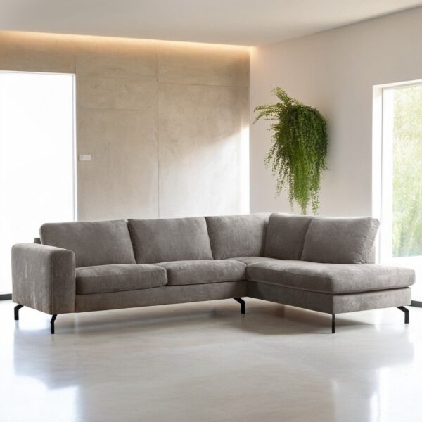 Moderne woonkamer met de 3-zits hoek rechts bank in Perfect Harmony 04 stof, R720 champagne, op zwarte poten. De bank staat op een lichte vloer met een groot raam, beige muren en een groene hangplant voor een luchtige, minimalistische look.