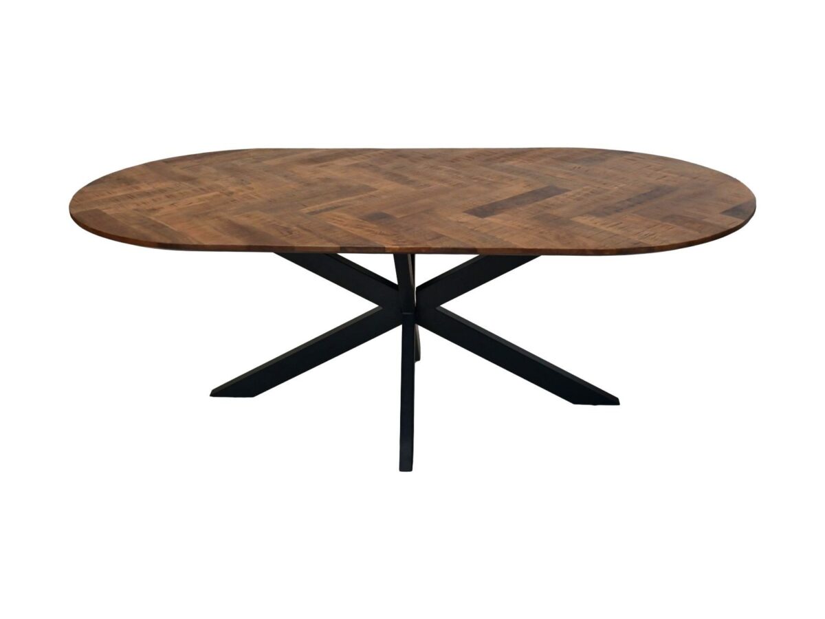 Ovale houten tafel met een patroonoppervlak dat wordt ondersteund door een zwarte, kruisvormige metalen basis. Het tafelblad heeft een visgraatmotief.