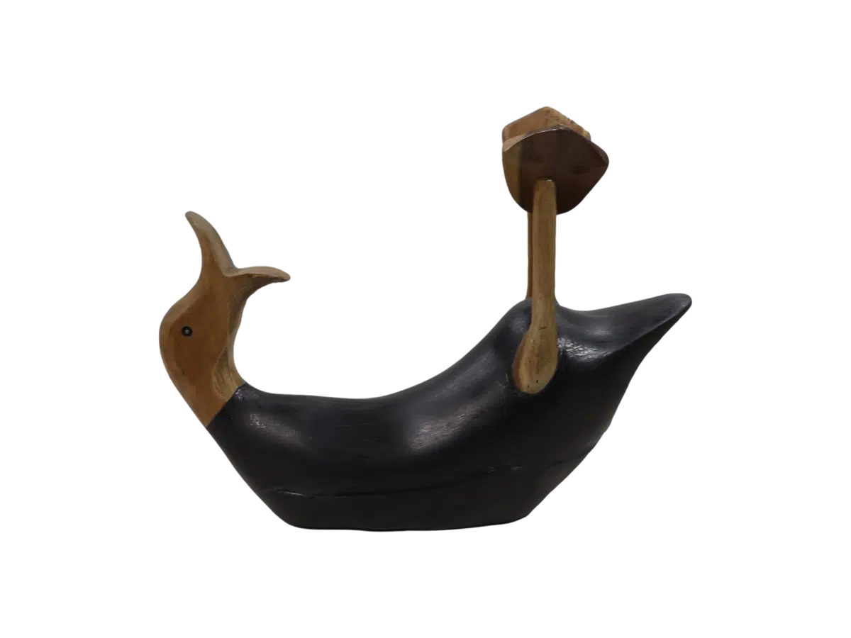 Een houten sculptuur van een gestileerde vogel in zwart en natuurlijk bruin. Het heeft een open snavel, vloeiende rondingen en een platte, verlengde staart met een dun, verticaal houten element aan de achterkant. De achtergrond is wit.