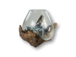Een handgeblazen glazen vaas met een druppelvorm rust op een robuuste, natuurlijke houten basis. Het glas lijkt te smelten en over het hout te vloeien, waardoor een harmonieuze mix van materialen en texturen ontstaat.