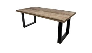 Een houten tafel met een rechthoekig blad en twee zwarte metalen poten in een U-vorm. Het tafelblad heeft een natuurlijke houtnerfstructuur, wat het een rustieke uitstraling geeft. De tafel staat tegen een witte achtergrond.