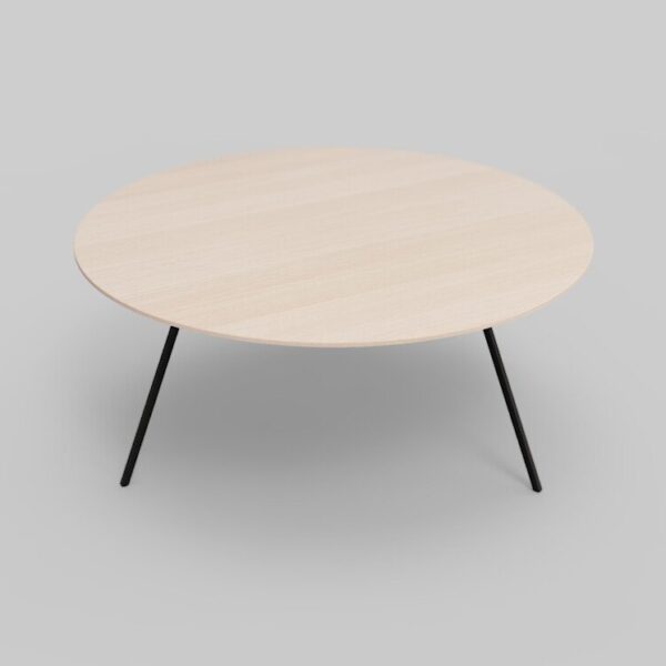 Een minimalistische ronde houten tafel met een lichte afwerking, voorzien van drie zwarte metalen poten, tegen een effen grijze achtergrond.
