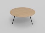 Een eenvoudige ronde houten tafel met een lichtbruin blad en slanke, zwarte metalen poten, tegen een effen lichtgrijze achtergrond.