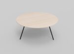Een minimalistische ronde salontafel met een licht houten blad en drie slanke zwarte poten. De tafel staat tegen een effen grijze achtergrond.