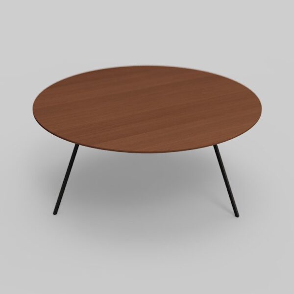Een ronde houten tafel met vier slanke, zwarte metalen poten op een lichtgrijze achtergrond.