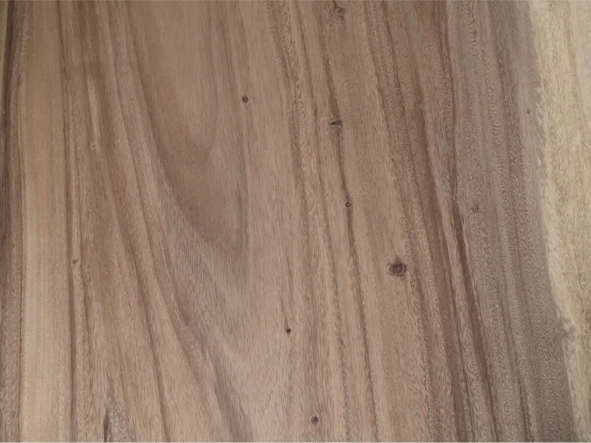 Glad houten oppervlak met natuurlijke nerfpatronen in tinten bruin, met af en toe kleine knopen en variaties in textuur. Het hout vertoont een mix van lichte en donkere strepen, wat de organische, rustieke uitstraling versterkt.
