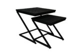 Twee moderne, zwarte, metalen nesttafels met vierkante bladen. De grotere tafel heeft een hogere structuur, terwijl de kleinere er gedeeltelijk onder past. Beide hebben een zigzagpatroon op het blad en hoekige, minimalistische poten. Tegen een witte achtergrond.