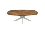 Een ovale houten tafel met een visgraatmotief op het tafelblad en een wit, X-vormig metalen onderstel, tegen een witte achtergrond.
