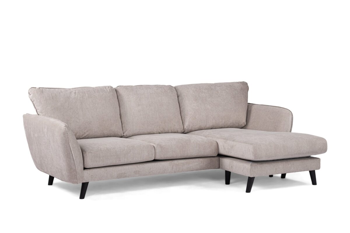 Een lichtgrijze, driezits sectionele bank met zachte kussens en een chaise longue aan de rechterkant. De bank heeft strakke zwarte poten en een modern design, dat comfort en stijl combineert.