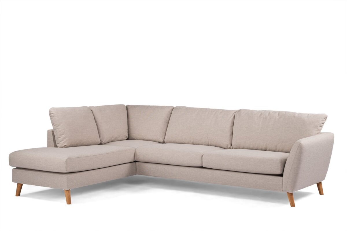 Een lichtbeige L-vormige sectionele bank met zachte kussens en houten poten, tegen een witte achtergrond. Het eigentijdse ontwerp heeft een chaise longue aan de linkerkant, wat comfortabele zitplaatsen biedt voor meerdere personen.