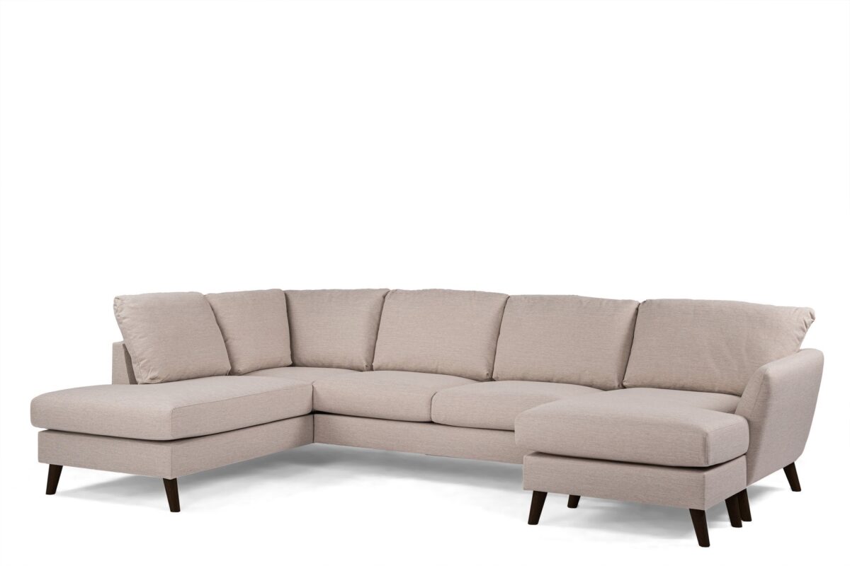 Een beige L-vormige hoekbank met zachte kussens en donkere houten poten, geplaatst tegen een effen witte achtergrond.