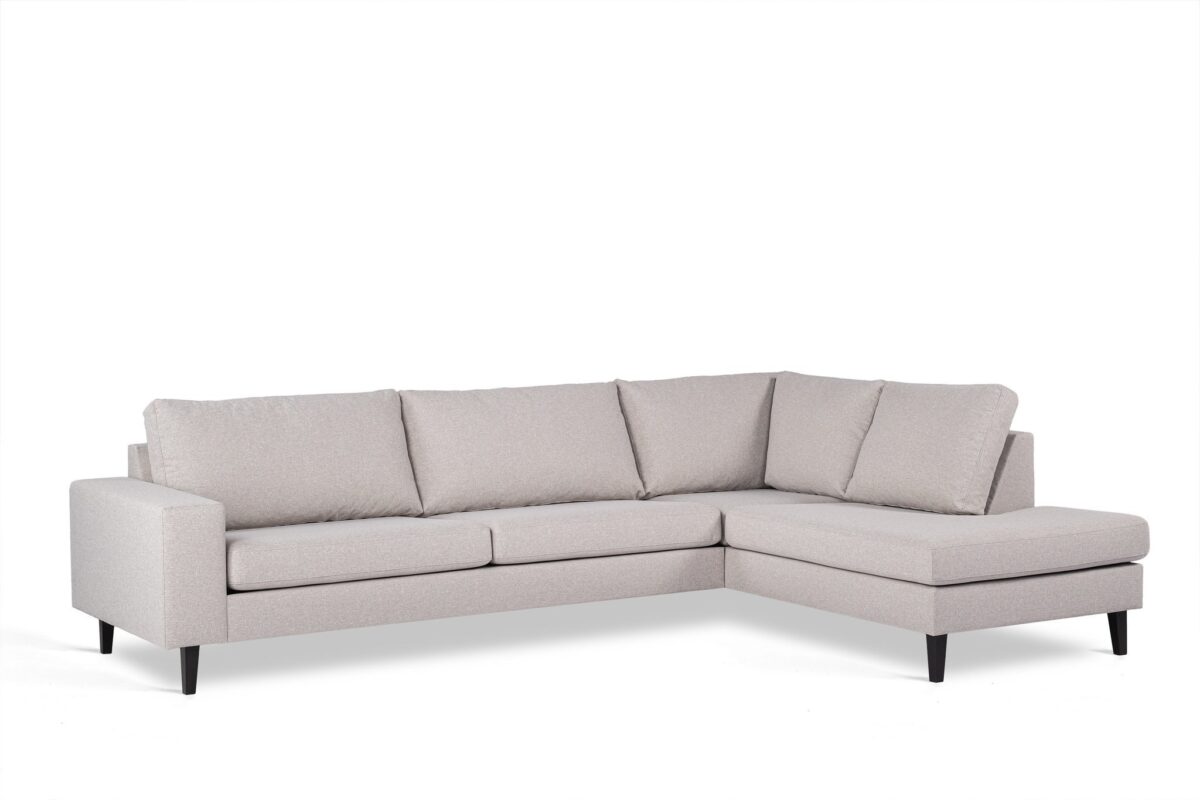 Een lichtgrijze L-vormige sectionele bank met drie zitkussens en bijpassende rugkussens. Het heeft strakke lijnen, een modern design en donkere houten poten, tegen een effen witte achtergrond.