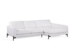 Een moderne witte sectionele bank met drie rugkussens en een verlengde chaise longue aan de rechterkant. Het heeft strakke lijnen en zwarte metalen poten, tegen een witte achtergrond.