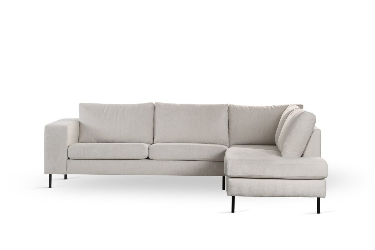 Een moderne beige L-vormige sectionele bank (3 zits hoek rechts, stof Lord 22, E460) met drie zit- en rugkussens en slanke zwarte metalen poten, getoond tegen een witte achtergrond.