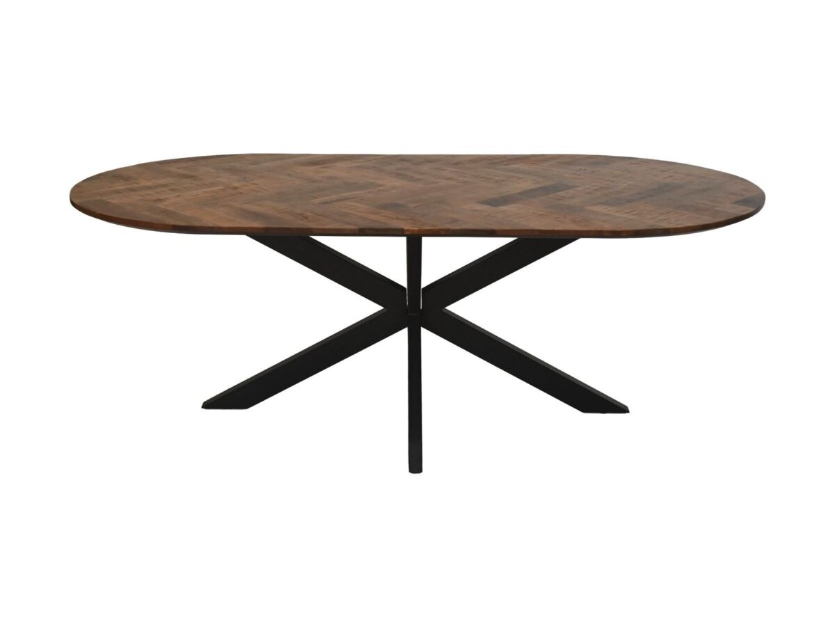 Een ovale houten eettafel met een visgraatmotief op het tafelblad en een zwart metalen X-vormig onderstel.