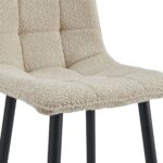 Een moderne stoel met een getextureerde beige stoffen zitting met gestikte vierkante patronen. Het heeft zwarte metalen poten. Het ontwerp van de stoel is minimalistisch en eigentijds, geschikt voor verschillende interieurstijlen.