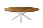 Een ronde houten tafel met een visgraatmotief op het tafelblad en een witte, gekruiste voet.