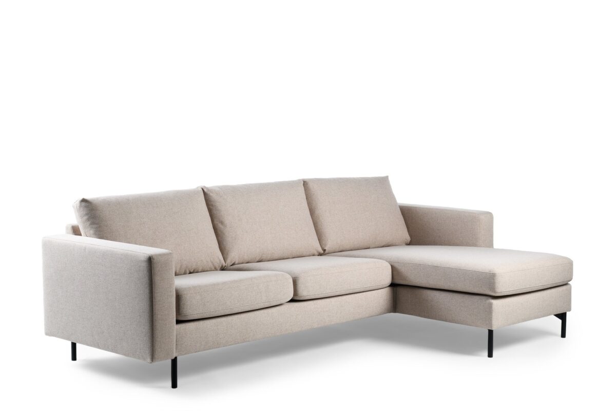 De 3 zits bank CL L+R in C460 beige Chloe stof heeft drie zit- en rugkussens, een chaise lounge aan de rechterkant en slanke zwarte metalen poten, afgebeeld tegen een witte achtergrond.