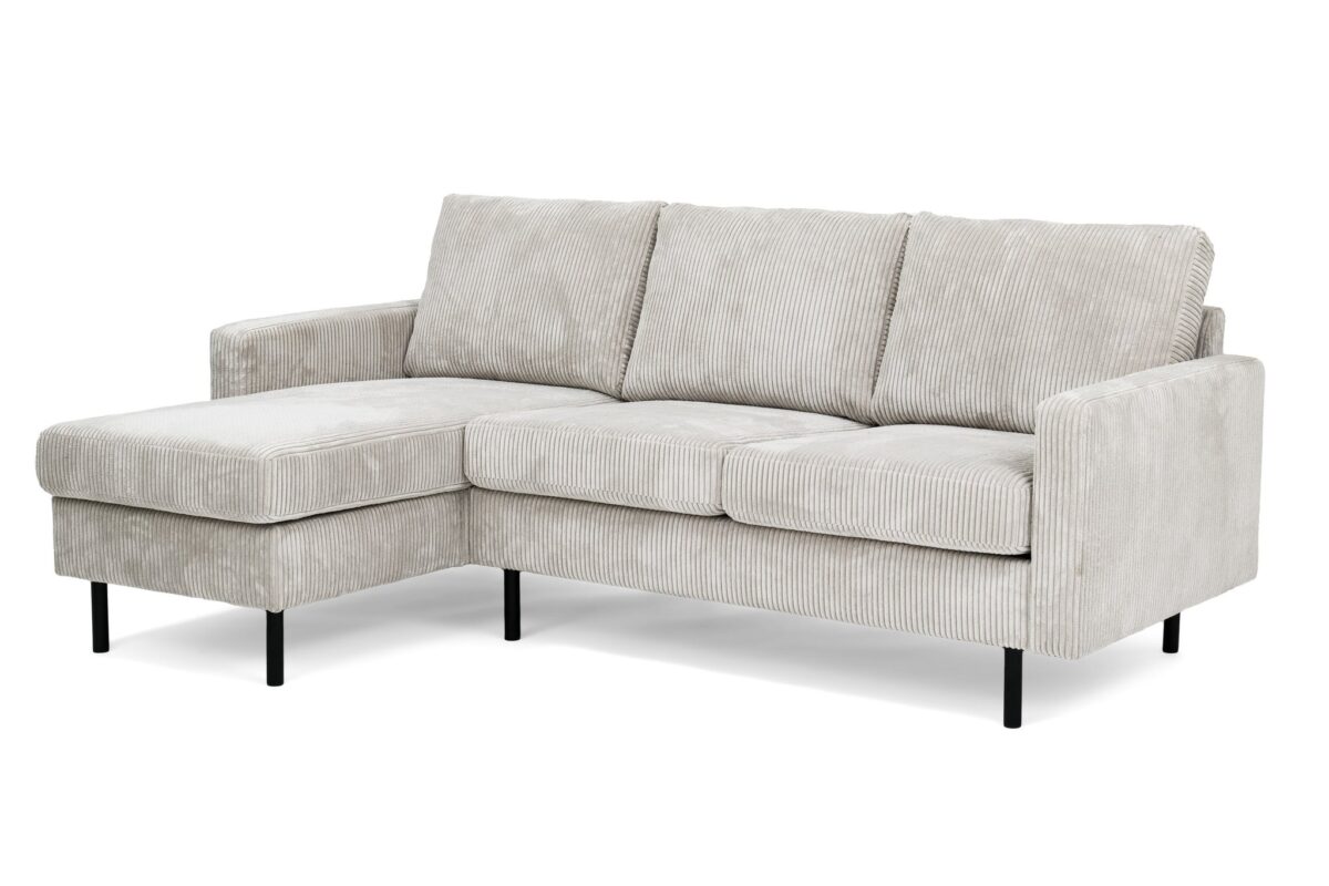 Een lichtbeige 3-zitsbank, model CL L+R in RIB920 naturel corduroy stof, met een chaise lounge aan de linkerkant en slanke zwarte metalen poten.
